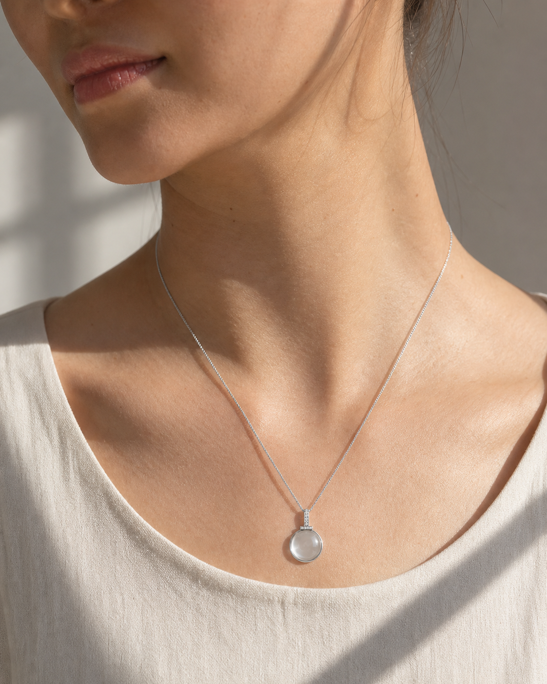 Clear quartz interchangeable pendant necklace worn in diagonal sunlight