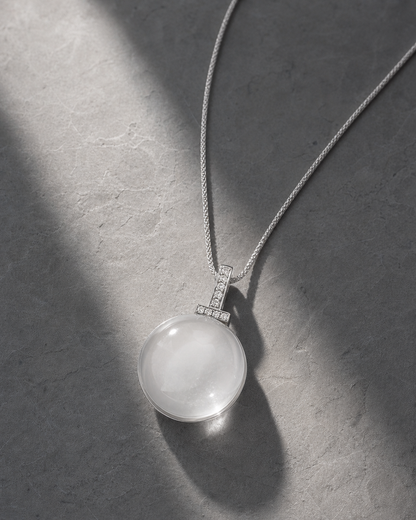 Clear quartz interchangeable pendant necklace on cool gray stone