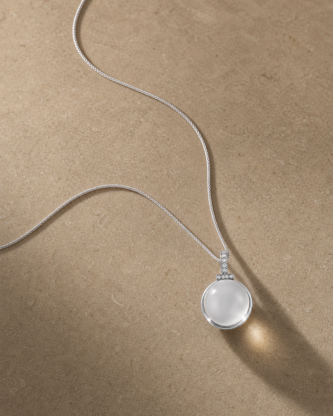Clear quartz interchangeable pendant necklace on warm caramel stone