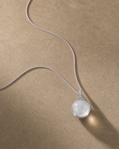 Clear quartz interchangeable pendant necklace on warm caramel stone